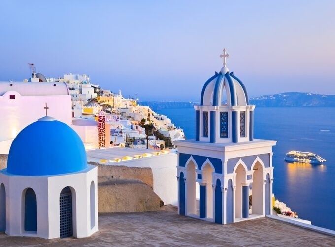 Santorini's volcanic rocks contrasting beautifully with Cycladic whitewashed buildings.